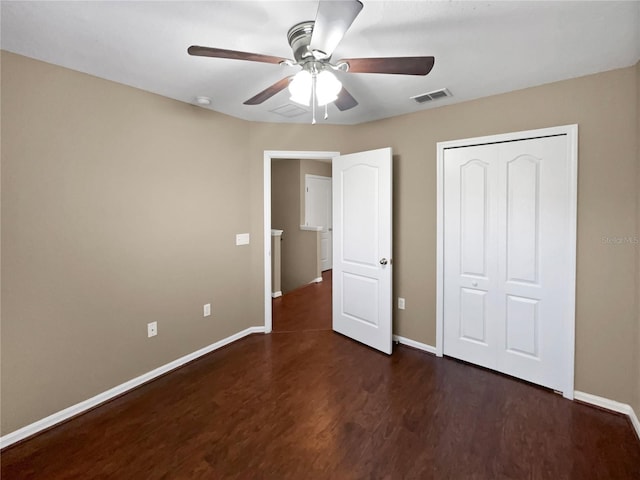 unfurnished bedroom featuring ceiling fan, dark hardwood / wood-style flooring, and a closet