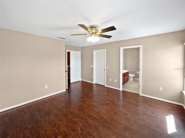 unfurnished bedroom with ensuite bath, dark wood-type flooring, and ceiling fan