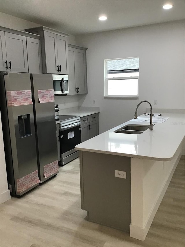 6915 SE 23rd Ave, Ocala, FL 34480 - kitchen with sink, a breakfast bar area, gray cabinetry, kitchen peninsula, and stainless steel appliances