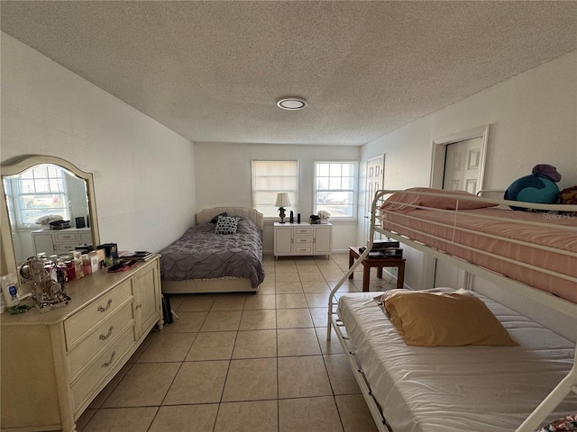 tiled bedroom featuring a textured ceiling