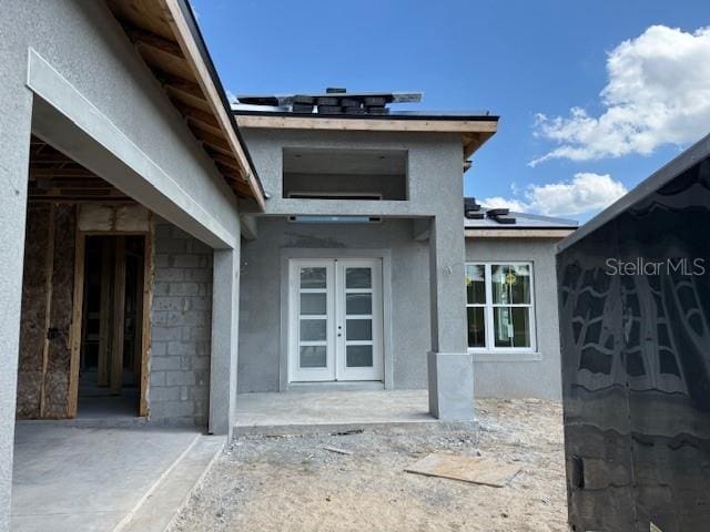 doorway to property featuring a patio, french doors, and solar panels