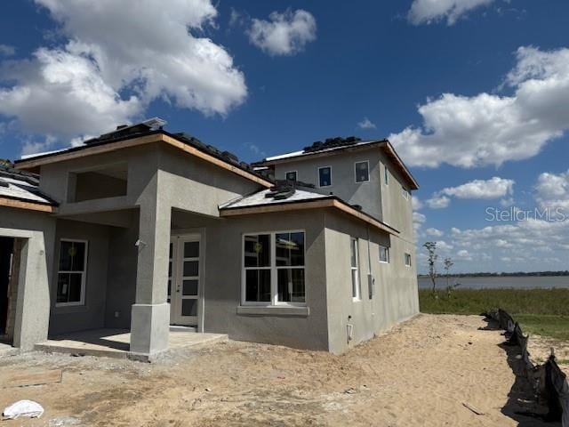 rear view of house featuring a patio area and stucco siding