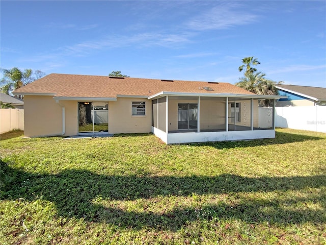 rear view of house featuring a yard and a sunroom