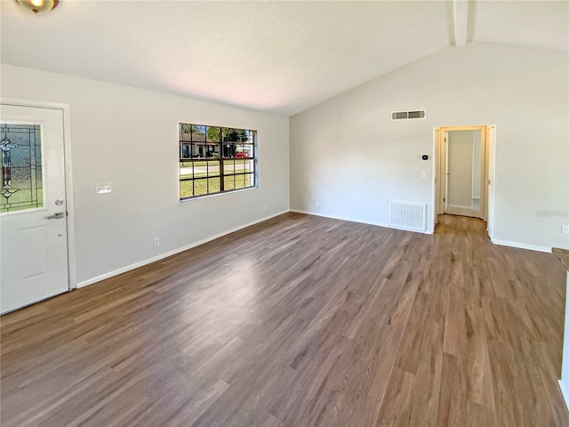 interior space with hardwood / wood-style flooring and vaulted ceiling with beams