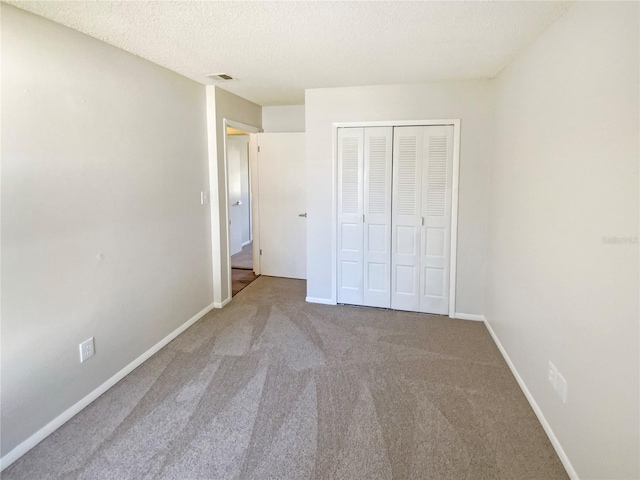 unfurnished bedroom with carpet flooring, a closet, and a textured ceiling