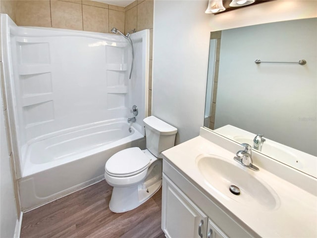 full bathroom with vanity, hardwood / wood-style floors, washtub / shower combination, and toilet