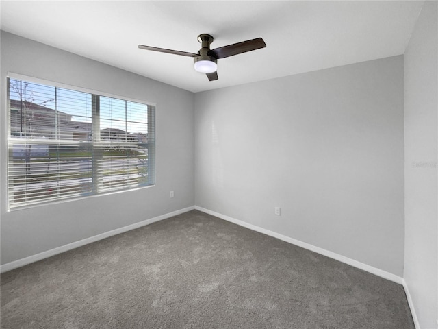 carpeted spare room featuring ceiling fan