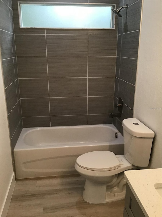 full bathroom with vanity, wood-type flooring, toilet, and tiled shower / bath