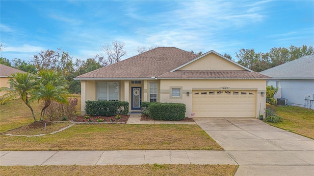 ranch-style house with a garage, cooling unit, and a front lawn