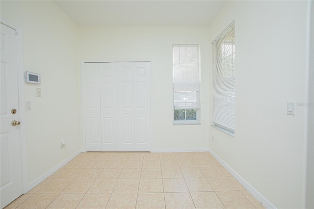 unfurnished room with light tile patterned flooring