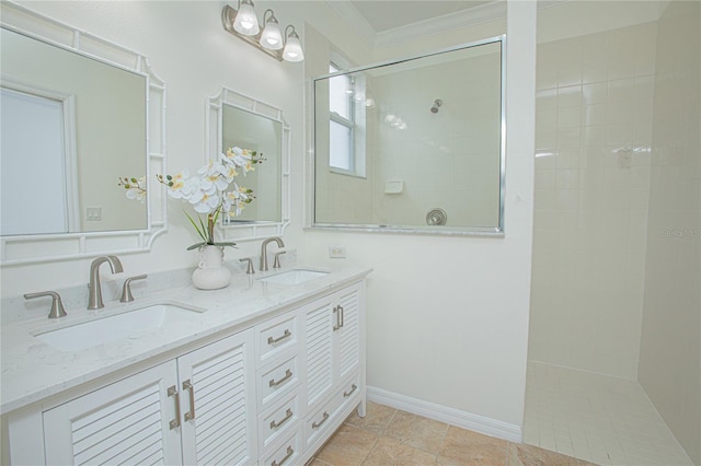 bathroom with tile patterned flooring, vanity, ornamental molding, and a tile shower