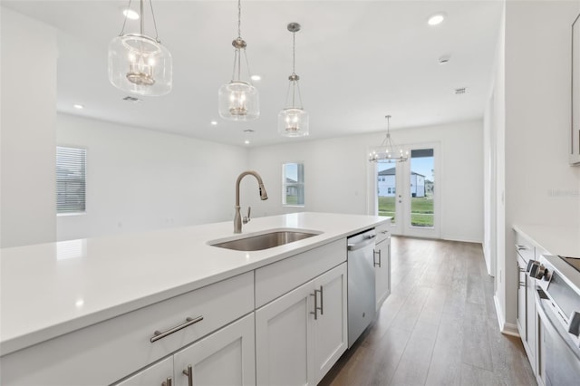 kitchen featuring sink, white cabinetry, hanging light fixtures, appliances with stainless steel finishes, and dark hardwood / wood-style floors