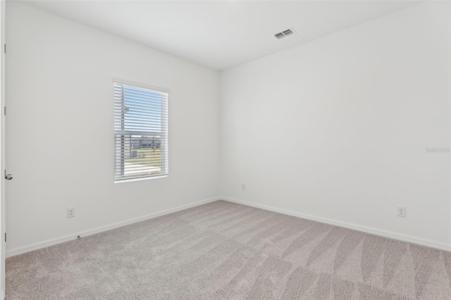 spare room featuring light colored carpet