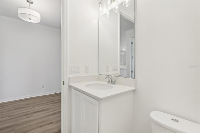 bathroom with hardwood / wood-style flooring, vanity, and toilet