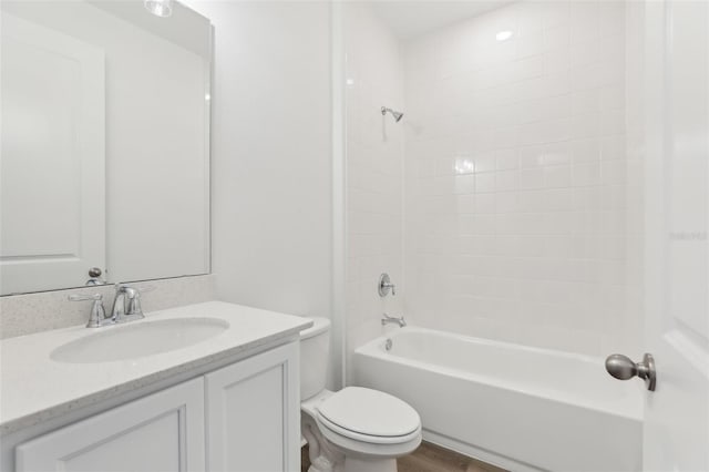 full bathroom featuring tiled shower / bath, vanity, toilet, and wood-type flooring