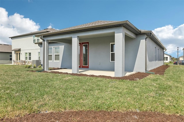 rear view of property with a yard, central AC unit, and a patio area