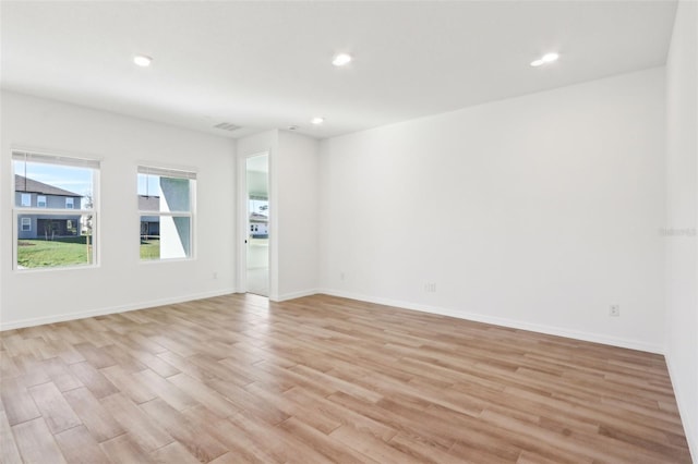 empty room with baseboards, recessed lighting, visible vents, and light wood-style floors