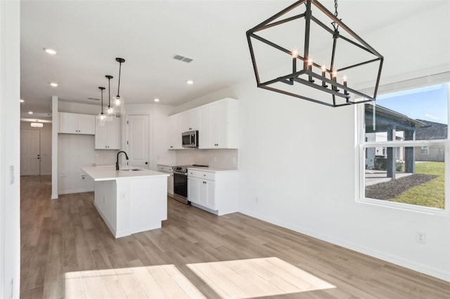 kitchen with visible vents, appliances with stainless steel finishes, light wood-type flooring, white cabinetry, and a sink