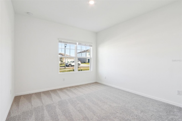 carpeted empty room featuring baseboards