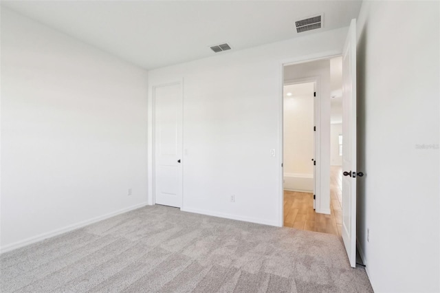 unfurnished bedroom with carpet floors, visible vents, and baseboards