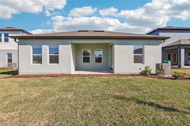 rear view of house featuring a patio area, cooling unit, a lawn, and stucco siding