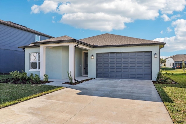 view of front facade with stucco siding, a shingled roof, concrete driveway, a front yard, and a garage