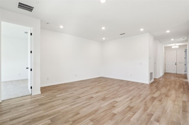 spare room featuring light wood-style floors, recessed lighting, and visible vents