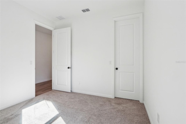 unfurnished bedroom featuring carpet floors, baseboards, and visible vents