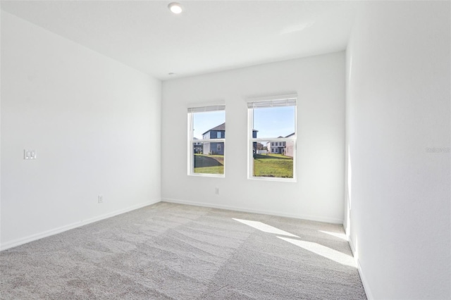 carpeted empty room with baseboards