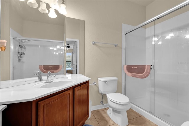 bathroom featuring toilet, vanity, a shower stall, tile patterned floors, and an inviting chandelier