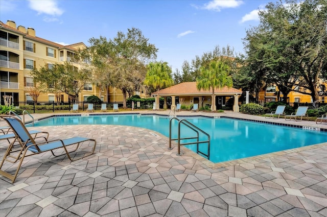 community pool featuring fence and a patio