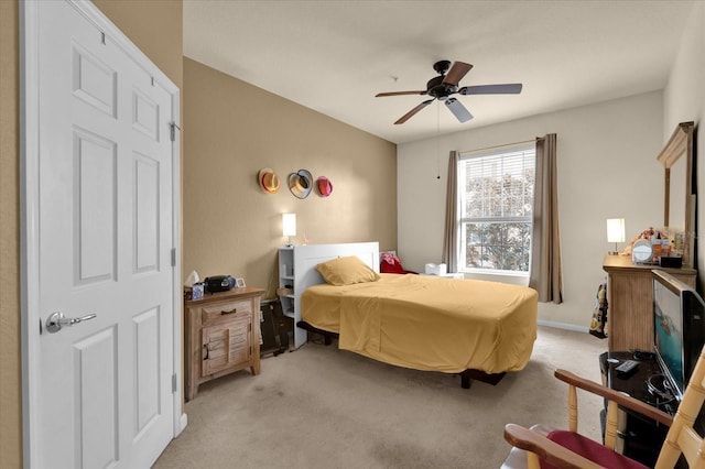 bedroom featuring light carpet and a ceiling fan