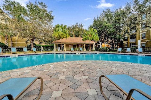 pool featuring fence and a patio