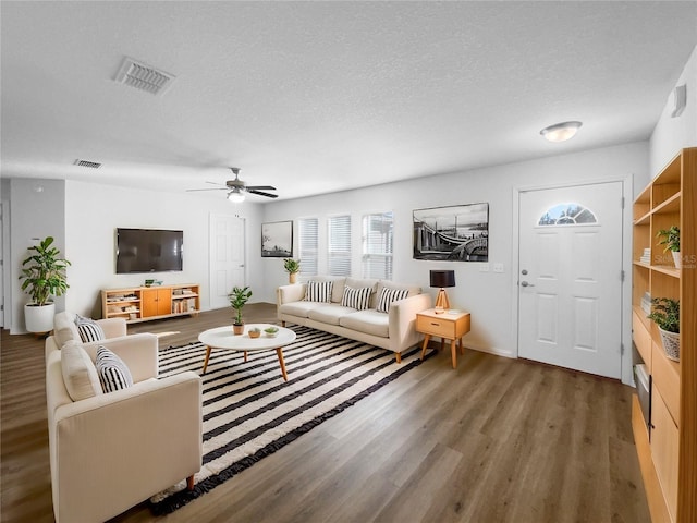 living room with ceiling fan, hardwood / wood-style floors, and a textured ceiling