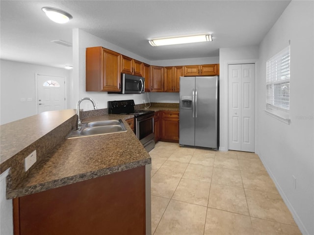 kitchen featuring light tile patterned flooring, appliances with stainless steel finishes, and sink