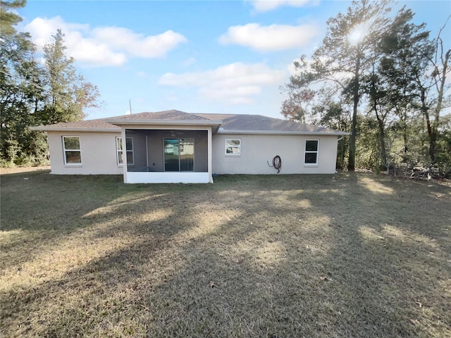 rear view of property with a sunroom and a lawn