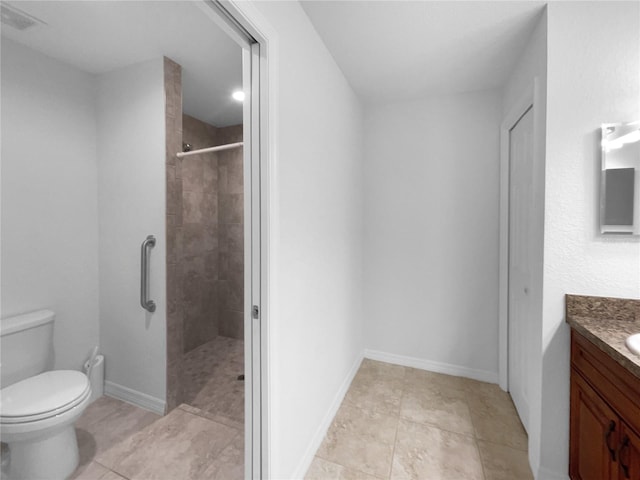 bathroom featuring vanity, tiled shower, and toilet