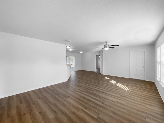 unfurnished living room with a textured ceiling, dark hardwood / wood-style floors, and ceiling fan