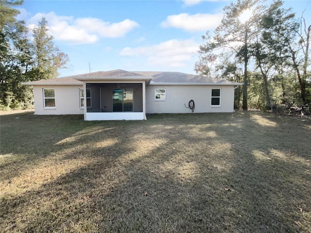 rear view of property with a sunroom and a lawn