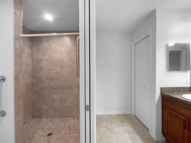 bathroom featuring tiled shower and vanity