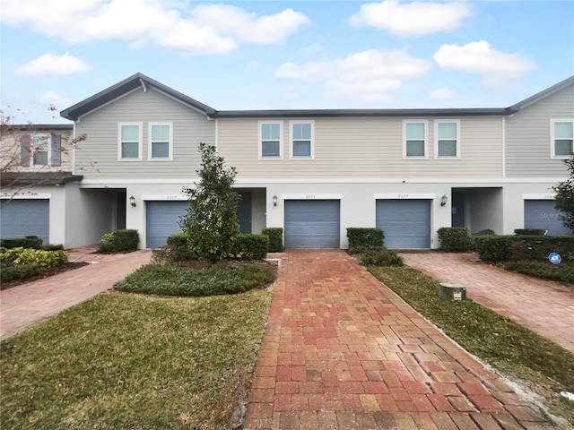 view of property featuring a garage and a front yard