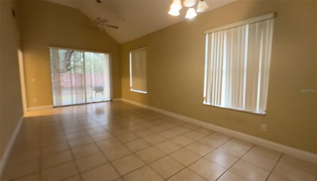 unfurnished room featuring ceiling fan with notable chandelier, vaulted ceiling, and light tile patterned floors