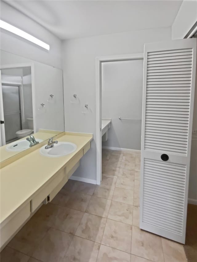 bathroom featuring sink, tile patterned floors, and toilet