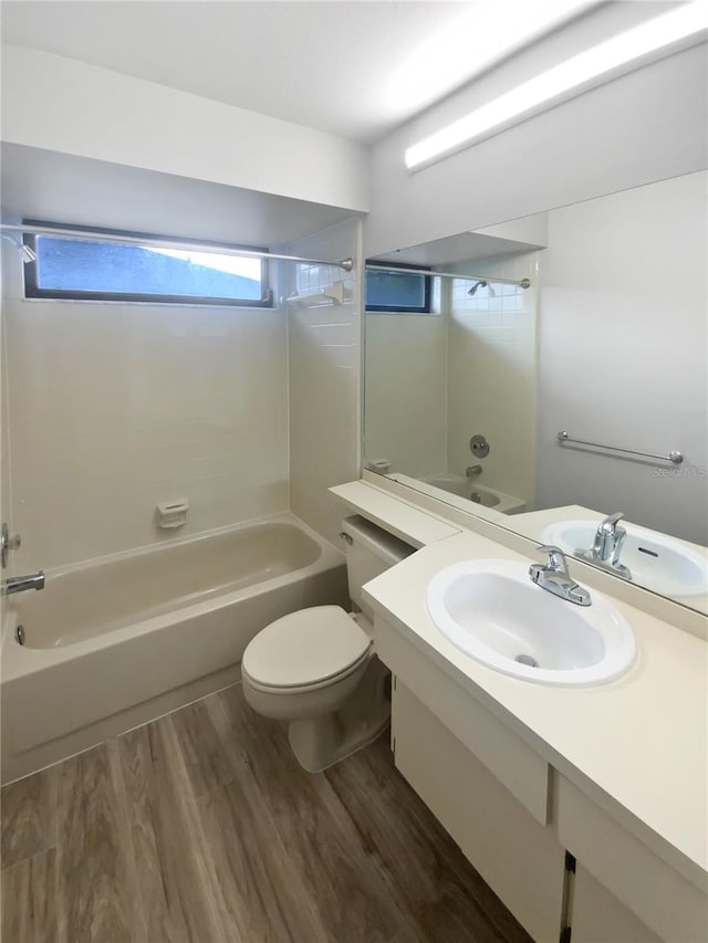 full bathroom with hardwood / wood-style flooring, bathing tub / shower combination, vanity, and toilet