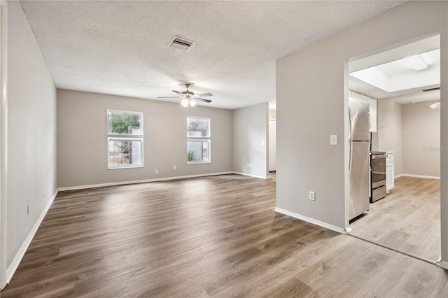 353 E Orange St, Altamonte Springs, FL 32701 - empty room featuring a textured ceiling, ceiling fan, and light hardwood / wood-style flooring
