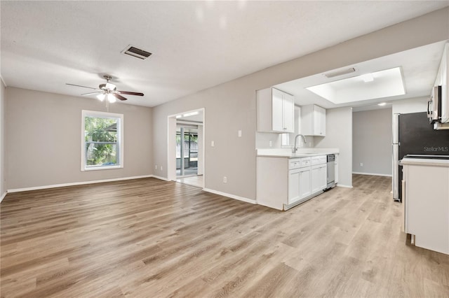 353 E Orange St, Altamonte Springs, FL 32701 - kitchen featuring appliances with stainless steel finishes, white cabinetry, sink, a tray ceiling, and light wood-type flooring
