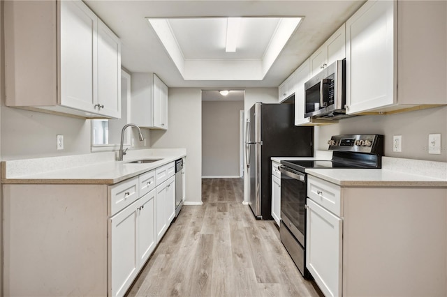 353 E Orange St, Altamonte Springs, FL 32701 - kitchen featuring white cabinetry, appliances with stainless steel finishes, sink, and a tray ceiling