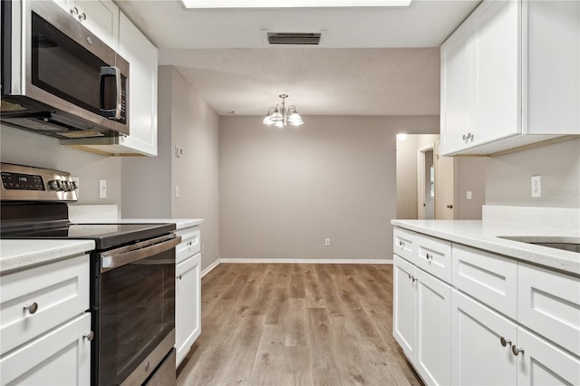 353 E Orange St, Altamonte Springs, FL 32701 - kitchen with white cabinetry, pendant lighting, light hardwood / wood-style flooring, and appliances with stainless steel finishes