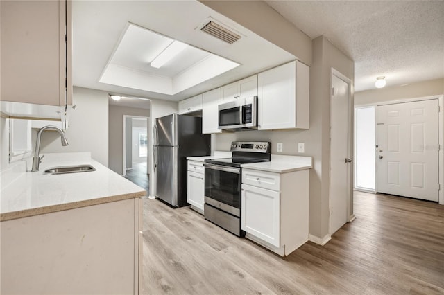 353 E Orange St, Altamonte Springs, FL 32701 - kitchen featuring white cabinetry, appliances with stainless steel finishes, sink, and light hardwood / wood-style flooring