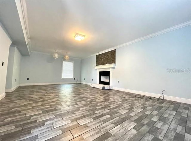 unfurnished living room featuring ornamental molding, a fireplace, wood finished floors, and baseboards